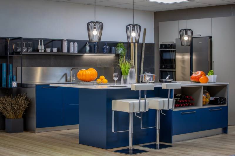 Vue d’ensemble d’une cuisine italienne sur mesure haut de gamme à Tresses, façades mates bleu polaire et silice, inox contemporain et électroménager Siemens à Bordeaux.