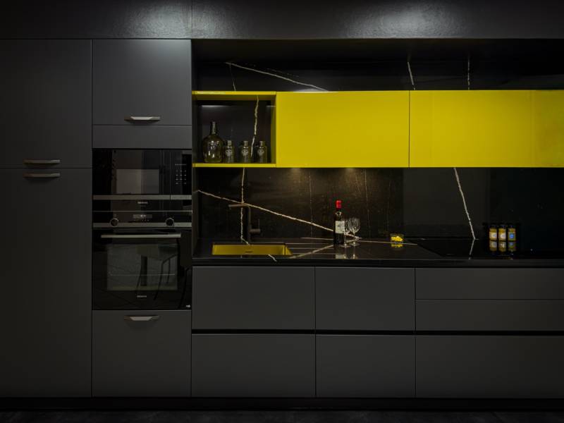 Cuisine italienne sur mesure exposée à Tresses – Laque jaune brillant, lavagna mat, quartz noir poli et évier cuve or.