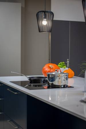 Îlot central de cuisine italienne sur mesure exposée à Tresses, près de Bordeaux, avec plaque de cuisson aspirante intégrée et plan de travail en quartz haut de gamme.