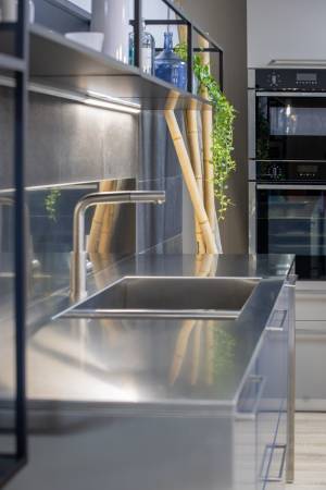 Plan de travail et crédence en inox brossé alimentaire avec double cuve soudée, au cœur d’une cuisine italienne haut de gamme exposée à Tresses, près de Bordeaux.