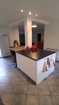 Un îlot central aux lignes modernes, intégrant rangements, électroménager et espace snack. L’association du granit noir et du bois crée un contraste chaleureux et contemporain.