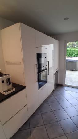 La fonctionnalité rencontre le design avec cette colonne en laque brillante accueillant un four et un micro-ondes encastrés. Une solution esthétique et pratique, conçue pour durer.