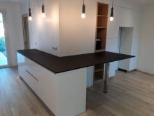 Installation d'une cuisine sur mesure avec un angle de meubles bas avec un plan débordant à la façon îlot snack sur la rive gauche