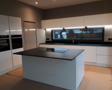 Cuisine contemporaine avec hotte de plan de travail intégrée en inox en sur la commune d'ARES
